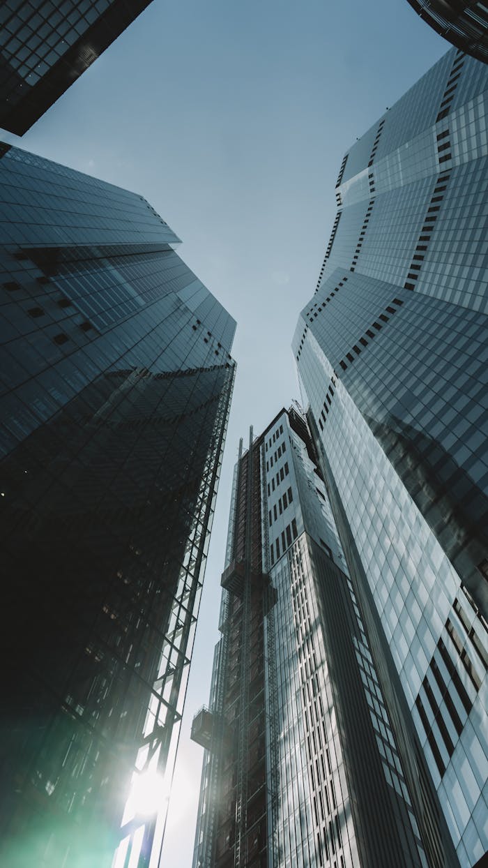 Upward view of iconic London skyscrapers with a clear, bright sky. Urban architecture marvel.
