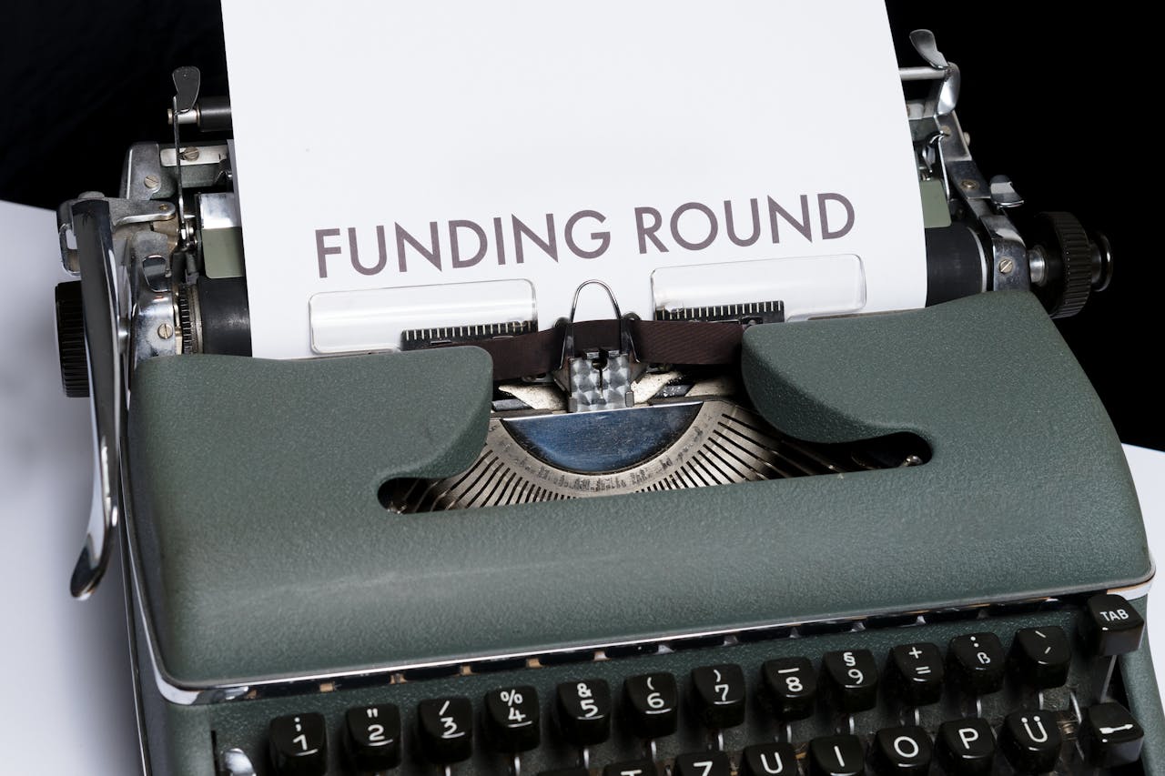 A vintage typewriter displaying the text 'Funding Round,' symbolizing investment and business planning.